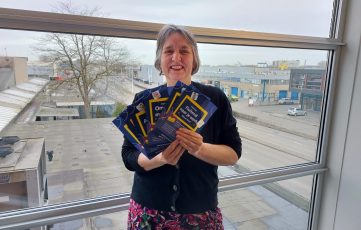 Opleidingscoördinator Jeanne Buwalda deelt flyers over trainingen bij Amfors uit