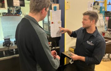 Praktijkbegeleider Theo begeleidt beschut werker Tom op werkvloer Metafors